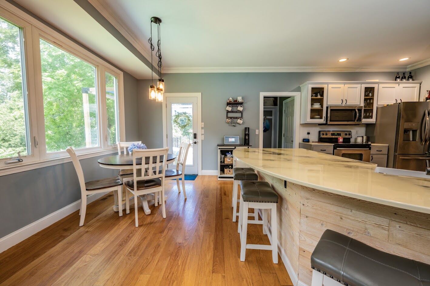 View across the bar seating toward the dining nook and rear door to the deck
