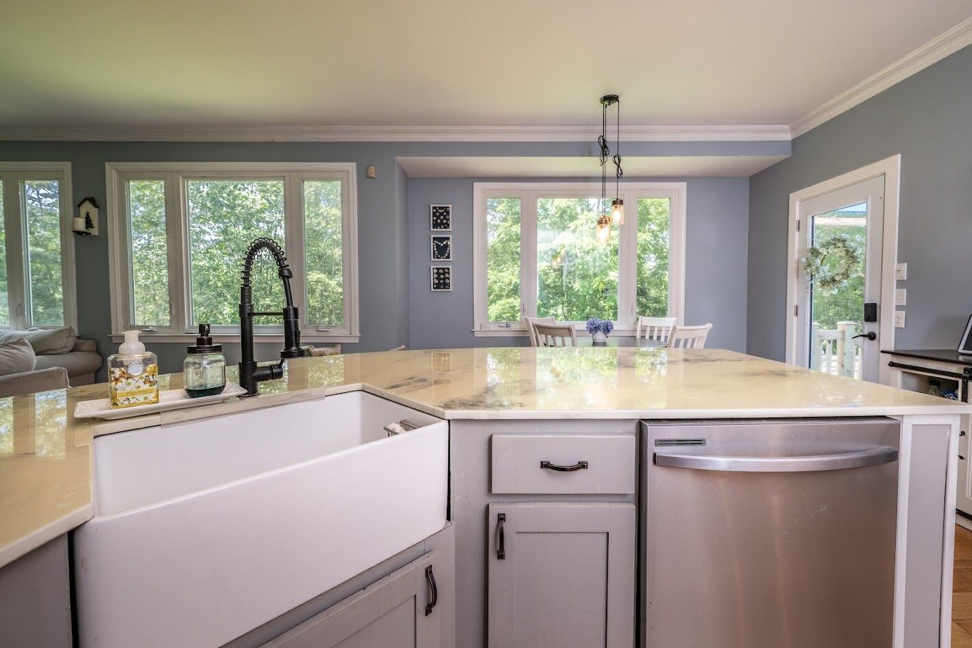 Kitchen island with white farmhouse apron sink, quartz counters, and matte black faucet