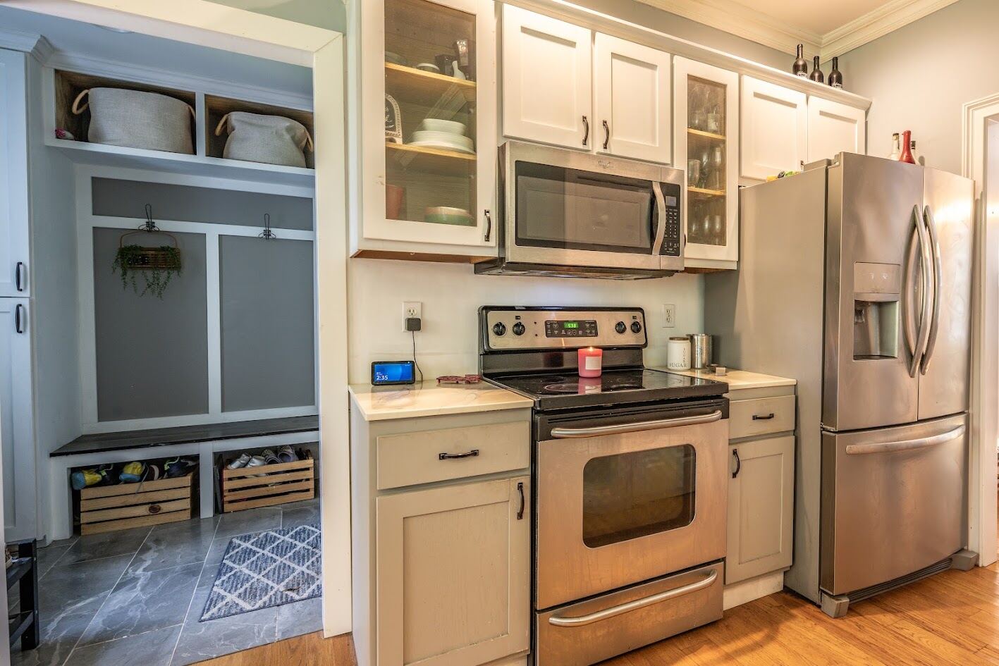 Range and refrigerator wall with a built-in mudroom bench and cubbies just beyond